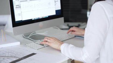 Kadın mimarların elleri klavyede yazı yazıyor, fareyi manipüle ediyor, mühendislik ve kentsel planlama için dijital planlar üzerinde çalışıyor. İş ve mimari kavramı