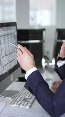 Dijital ve fiziksel yapı planlarını inceleyerek, mimari tasarım projesinde işbirliği yapan mühendislik uzmanları. İş adamları ve mimari konsepti