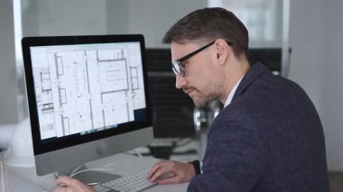 Mühendis, mimari planlama ve gayrimenkul geliştirme üzerine kurulu kaba yazılım üzerine modern bir bina planı tasarlıyor. İş ve mimari kavramı