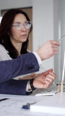 Mimarlar ve tasarımcılar ofiste işbirliği yapıyor, mimari proje geliştiriyor, model oluşturma ve bilgisayar planları üzerinde tartışıyorlar. İş adamları ve mimari konsepti