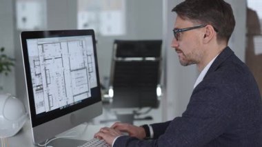 Mühendis, mimari planlama ve gayrimenkul geliştirme üzerine kurulu kaba yazılım üzerine modern bir bina planı tasarlıyor. İş ve mimari kavramı