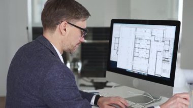 Mühendis, mimari planlama ve gayrimenkul geliştirme üzerine kurulu kaba yazılım üzerine modern bir bina planı tasarlıyor. İş ve mimari kavramı