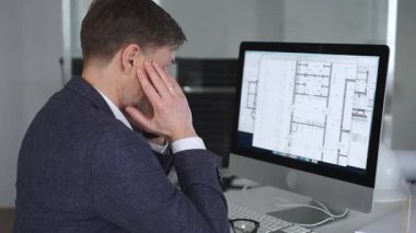 Stresli iş adamı ofis masasında baş ağrısı ve duygusal çöküntü yaşıyor, mimari projelerin teslim tarihleri ve iş baskısı altında eziliyor. İş ve mimari kavramı