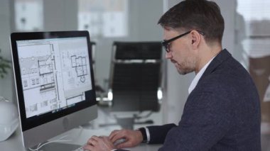 Mühendis, mimari planlama ve gayrimenkul geliştirme üzerine kurulu kaba yazılım üzerine modern bir bina planı tasarlıyor. İş ve mimari kavramı