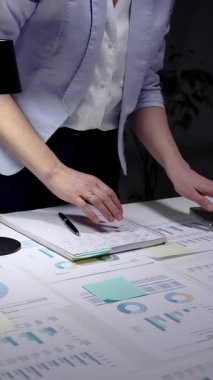 Finansal verileri yöneten iş kadını, gece geç saatlerde raporları analiz eden, laptopta fazla mesai yapan, karanlık bir ofiste masa başında duran, stratejik planlamalara konsantre olan..