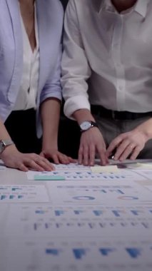 İş adamları pazarlama veri grafiklerini ve finansal grafikleri analiz ediyor, bir şirket projesinde işbirliği yapıyor, büyüme stratejisini tartışıyorlar.