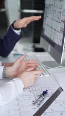 Dijital ve fiziksel yapı planlarını inceleyerek, mimari tasarım projesinde işbirliği yapan mühendislik uzmanları. İş adamları ve mimari konsepti