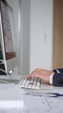 Erkek mimar, mimari bir stüdyoda yeni yapılar ve modeller tasarlayarak bilgisayar ekranına ve planlara derinden odaklanmıştır. İş ve mimari kavramı