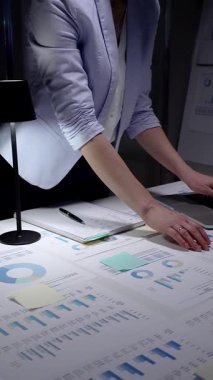 Finansal verileri yöneten iş kadını, gece geç saatlerde raporları analiz eden, laptopta fazla mesai yapan, karanlık bir ofiste masa başında duran, stratejik planlamalara konsantre olan..
