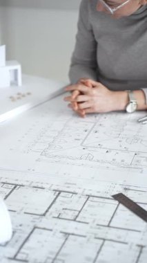 Modern mimari projesinde işbirliği yapan mimarlar, bina tasarımı, planlama, yaratıcılık ve sürdürülebilir inşaatın vurgulanması için ayrıntılı planlar ve 3D modeli gözden geçiriyorlar.