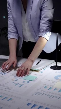 Finansal verileri yöneten iş kadını, gece geç saatlerde raporları analiz eden, laptopta fazla mesai yapan, karanlık bir ofiste masa başında duran, stratejik planlamalara konsantre olan..