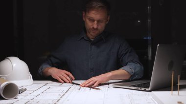 Mimari, profesyonel inşaat planlarını ve mühendislik planlarını geliştiriyor, özenle çiziyor, akşam saatlerinde üretken kalıyor.