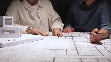 Teknik taslak çizimleri üzerinde işbirliği yapan mimarlar, yeni bina tasarımları ve konut geliştirme planlarını tartıştılar, inşaat projesi planlaması üzerinde dikkatle çalıştılar.