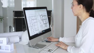 Kadın mimar bilgisayarda mimari projeler tasarlıyor, planlar, inşaat planları ve 3D modeller yapıyor. İş ve mimari kavramı