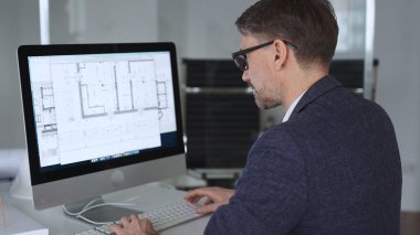 Mühendis, mimari planlama ve gayrimenkul geliştirme üzerine kurulu kaba yazılım üzerine modern bir bina planı tasarlıyor. İş ve mimari kavramı