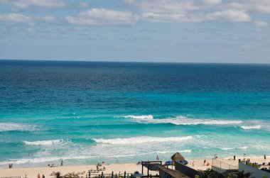 Turkuaz deniz suyu ve Meksika 'nın Cancun kentindeki güzel plajda dinlenen turistlerin büyüleyici manzarası.