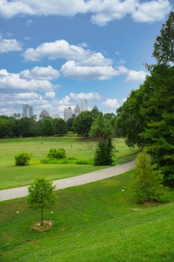 Sabahın erken saatlerinde Atlanta Belde Hattı boyunca koşan, bisikletle gezen ve köpeklerini Atlanta Skyline ve Piedmont Park 'ın panoramik manzarasıyla yürüten insanlar, bulutlu bir günde sıcak bir günde, Haziran 2021' de Atlanta sonrası salgınının yeniden başlaması sırasında....