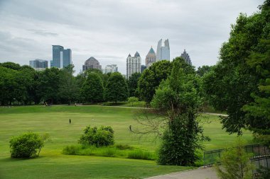 Sabahın erken saatlerinde Atlanta Belde Hattı boyunca koşan, bisikletle gezen ve köpeklerini Atlanta Skyline ve Piedmont Park 'ın panoramik manzarasıyla yürüten insanlar, bulutlu bir günde sıcak bir günde, Haziran 2021' de Atlanta sonrası salgınının yeniden başlaması sırasında....