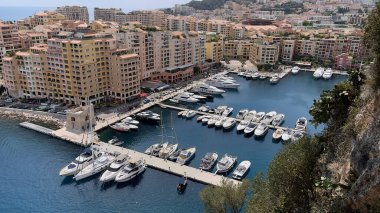 Monte Carlo, Monako-3 Ağustos 2021: Monte Carlo, Monaco 'daki güzel bir panoramik körfez manzarası ünlü Fransız rivierasının bir parçası süper lüks yatlar, botlar ve Akdeniz manzaralı tepenin üzerindeki güzel renkli evlerle donatılmış d