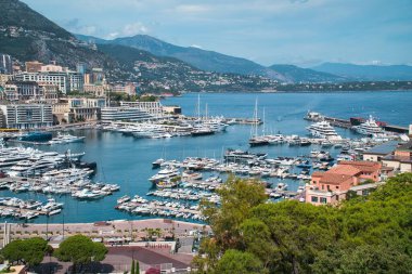 Monte Carlo, Monako-3 Ağustos 2021: Monte Carlo, Monaco 'daki güzel bir panoramik körfez manzarası ünlü Fransız rivierasının bir parçası süper lüks yatlar, botlar ve Akdeniz manzaralı tepenin üzerindeki güzel renkli evlerle donatılmış d