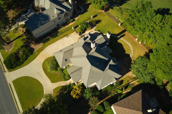 Aerial top down panoramic view of house cluster in a sub division in Suburbs with golf course and beautiful gardens shot during golden hour