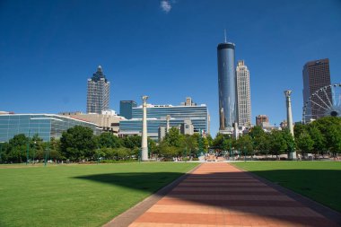 Atlanta, Georgia-25 Eylül 2021: Atlanta siluetinin panoramik manzarası, dönmedolabı ve olimpiyat yüzüncü yıl olimpiyat parkından olimpiyat halkaları ve güzel bir sonbahar öğleden sonrasında parkta yürüyüp dinlenen insanlar