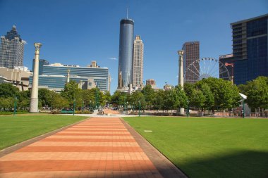 Atlanta, Georgia-25 Eylül 2021: Atlanta siluetinin panoramik görüntüsü, dönmedolabı ve olimpik halkalar yüzüncü yıl olimpiyat parkından ve güzel bir sonbahar öğleden sonrasında eğlenen insanlar.