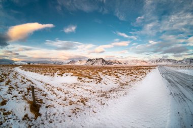 İzlanda 'da kış mevsimi manzarası. Plato ve karla kaplı uzak dağ sırtı. Bulutlu mavi gökyüzü. 