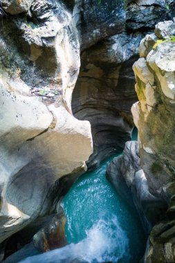 Kayaların arasına düşen turkuaz suyun yüksek açılı görüntüsü. Su erozyonunun oluşturduğu dar geçit..