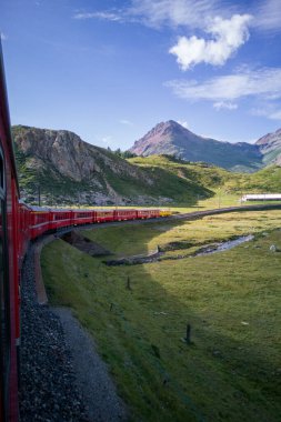 Meşhur kırmızı Bernina Ekspres treni yaz aylarında Alp Dağları 'nda yol alır. Trenin camından vurulmuş..