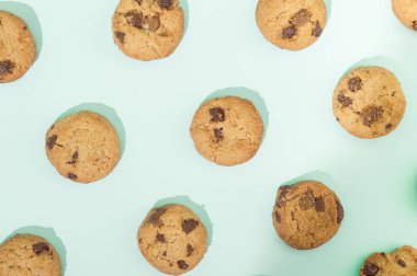 Çikolata parçalı kurabiyeler turkuaz arka planda düzenlenmiş. Tatlı yemek konsepti.