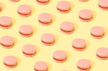 Pembe makarnalar sarı arkaplanda bir desen oluşturmuşlar. Tatlı pasta konsepti