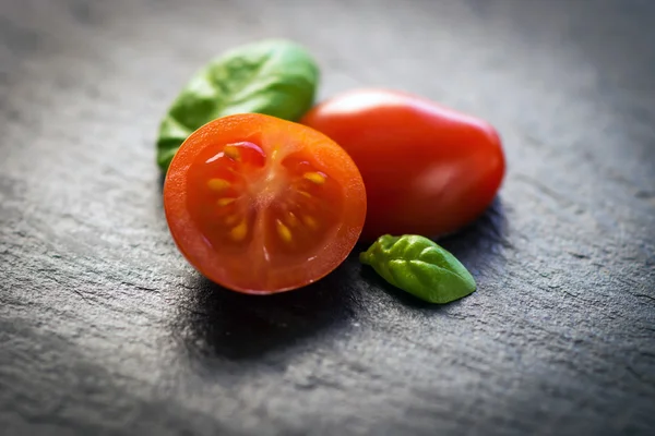 Pomodori ciliegia e foglie di basilico — Foto Stock