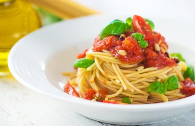 Spagetti domates ve fesleğen yaprakları ve biber ile