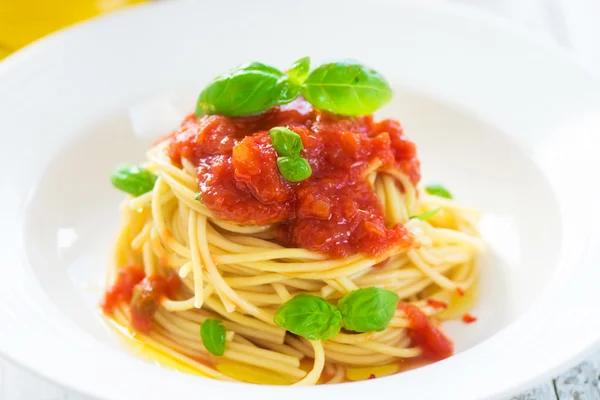 Spagetti tomaatin ja basilikan lehdillä ja chilillä — kuvapankkivalokuva