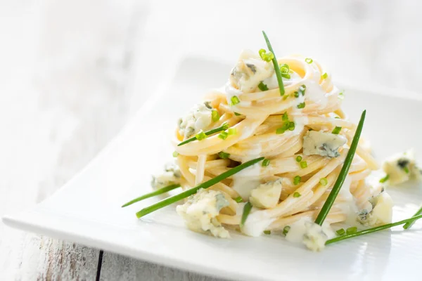 Pasta with gorgonzola on a wooden background — Stock Photo, Image