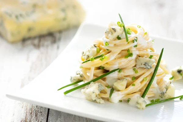 Pasta with gorgonzola on a wooden background — Stock Photo, Image