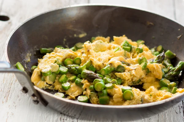 Green asparagus with egg in a frying pan. — Stock Photo, Image