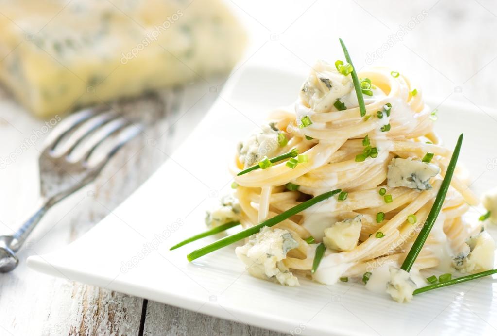 Pasta with gorgonzola on a wooden background