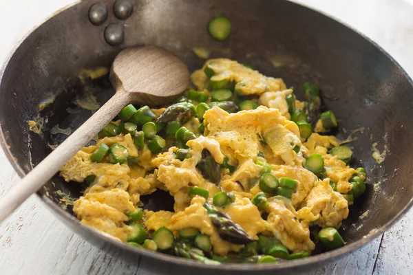 Green asparagus with egg in a frying pan. — Stock Photo, Image