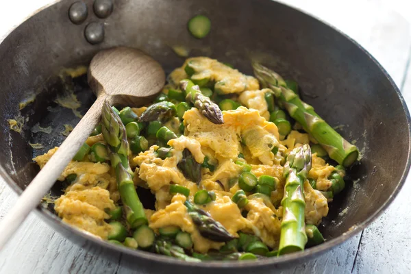 Green asparagus with egg in a frying pan. — Stock Photo, Image