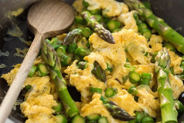 Green asparagus with egg in a frying pan. — Stock Photo, Image