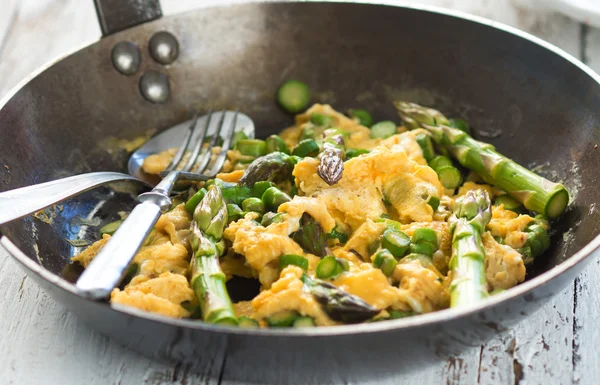 Green asparagus with egg in a frying pan. — Stock Photo, Image