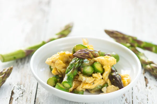 Yeşil kuşkonmaz ve ahşap arka plan üzerinde yumurta