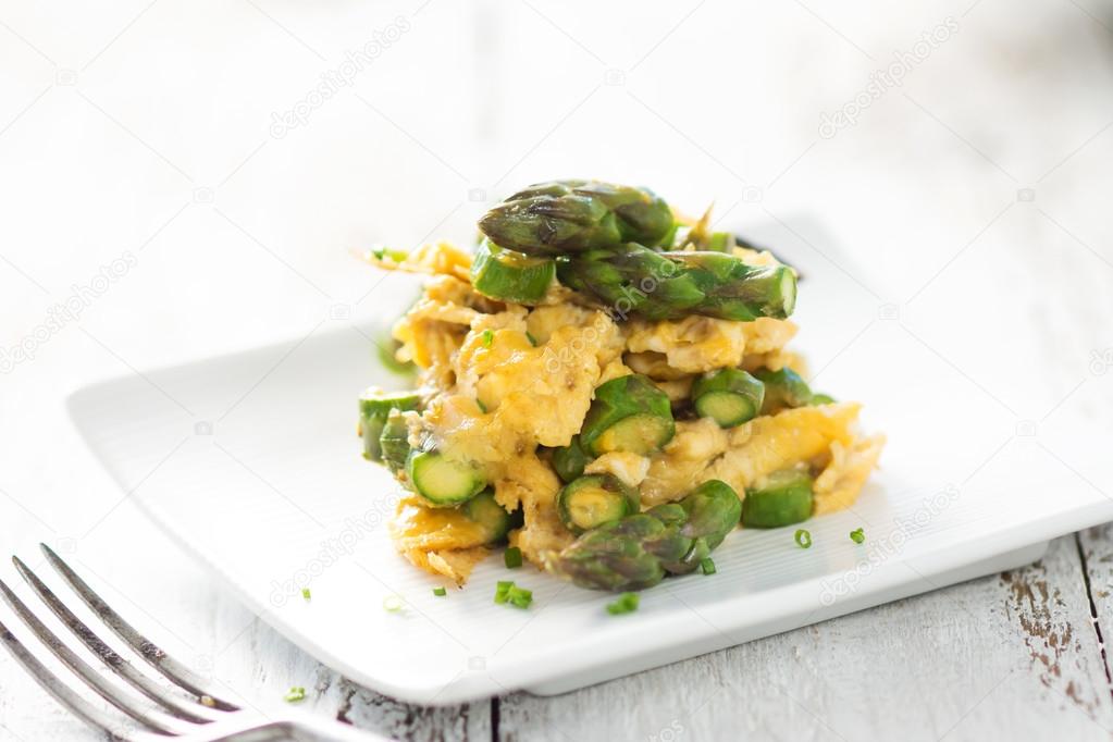 Green asparagus and eggs on wooden background