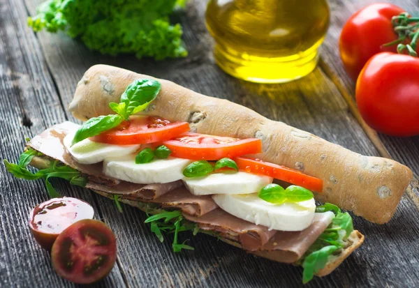 Sandwich mit knusprigem Baguette auf Holzboden — Stockfoto