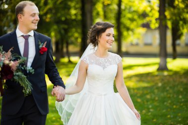 Güzel gelin ve damat güneşli bir parkta