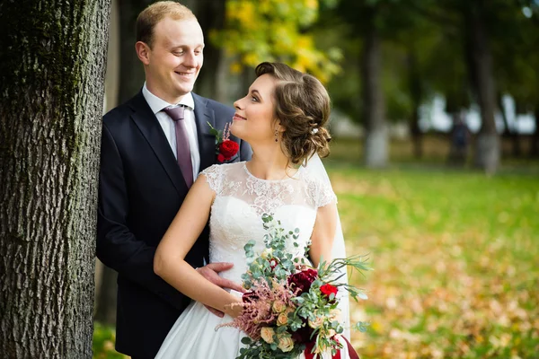 Mooie bruid en bruidegom in het park op een zonnige dag — Stockfoto