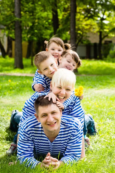 Família feliz no parque em um dia ensolarado de verão — Fotografia de Stock