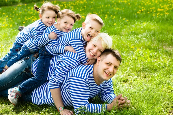 Familia feliz divirtiéndose en el parque en un soleado día de verano — Foto de Stock